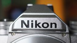 Close-up of the Nikon logo on a silver Nikon Zfc camera