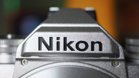 Close-up of the Nikon logo on a silver Nikon Zfc camera