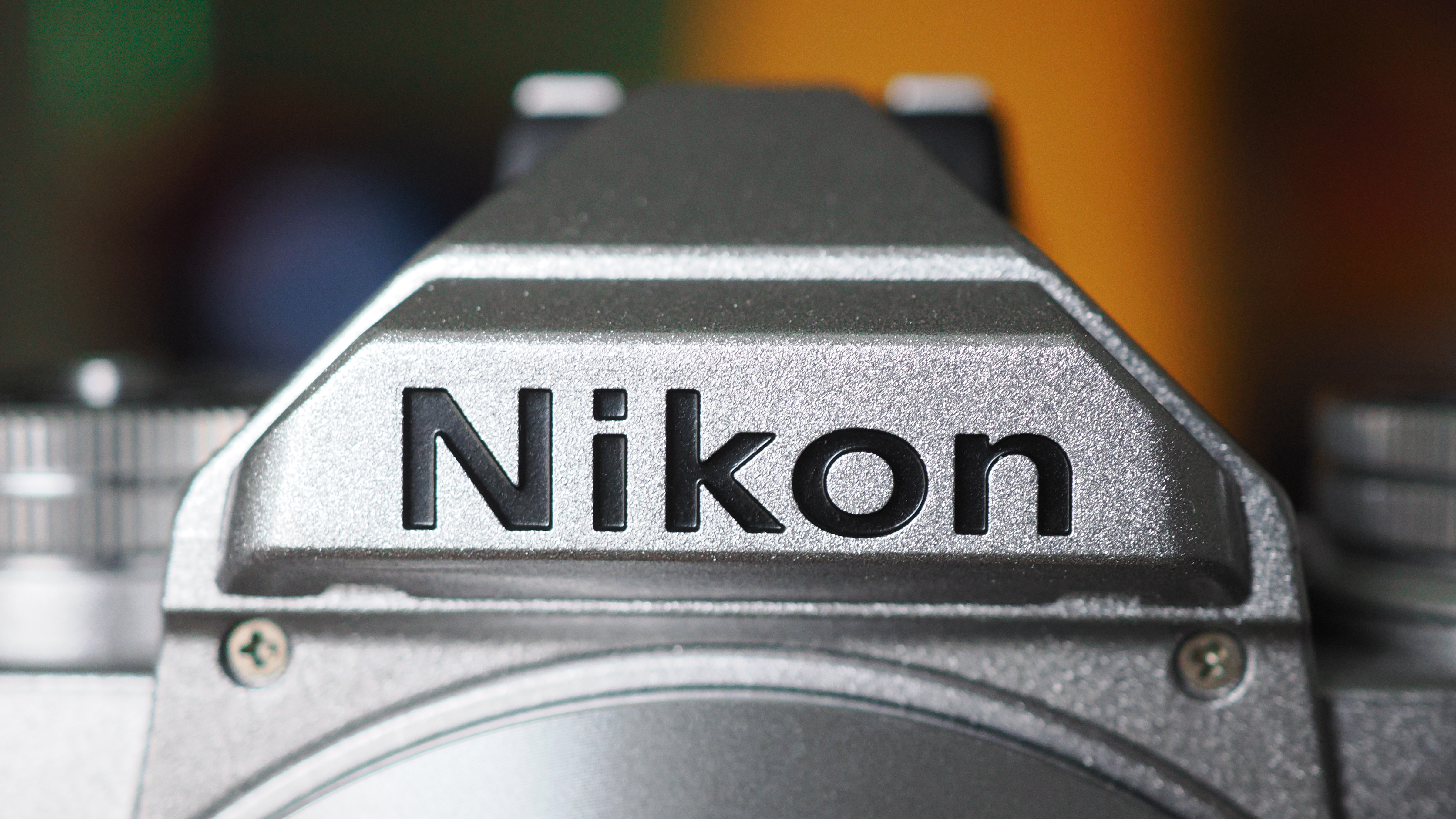 Close-up of the Nikon logo on a silver Nikon Zfc camera