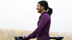 Woman doing cycling as a workout in forest smiling