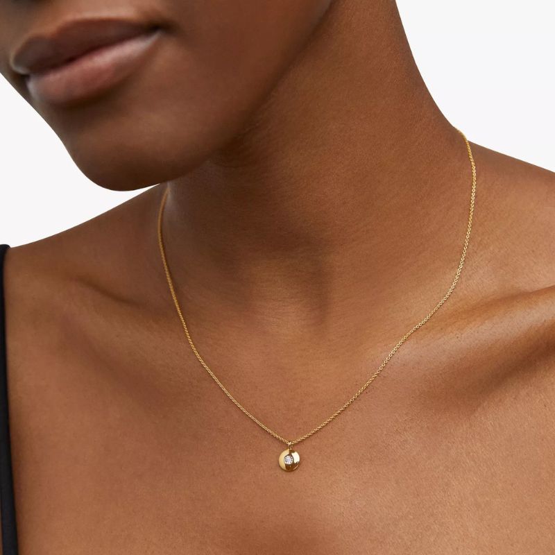 A woman wearing a Monica Vinader necklace