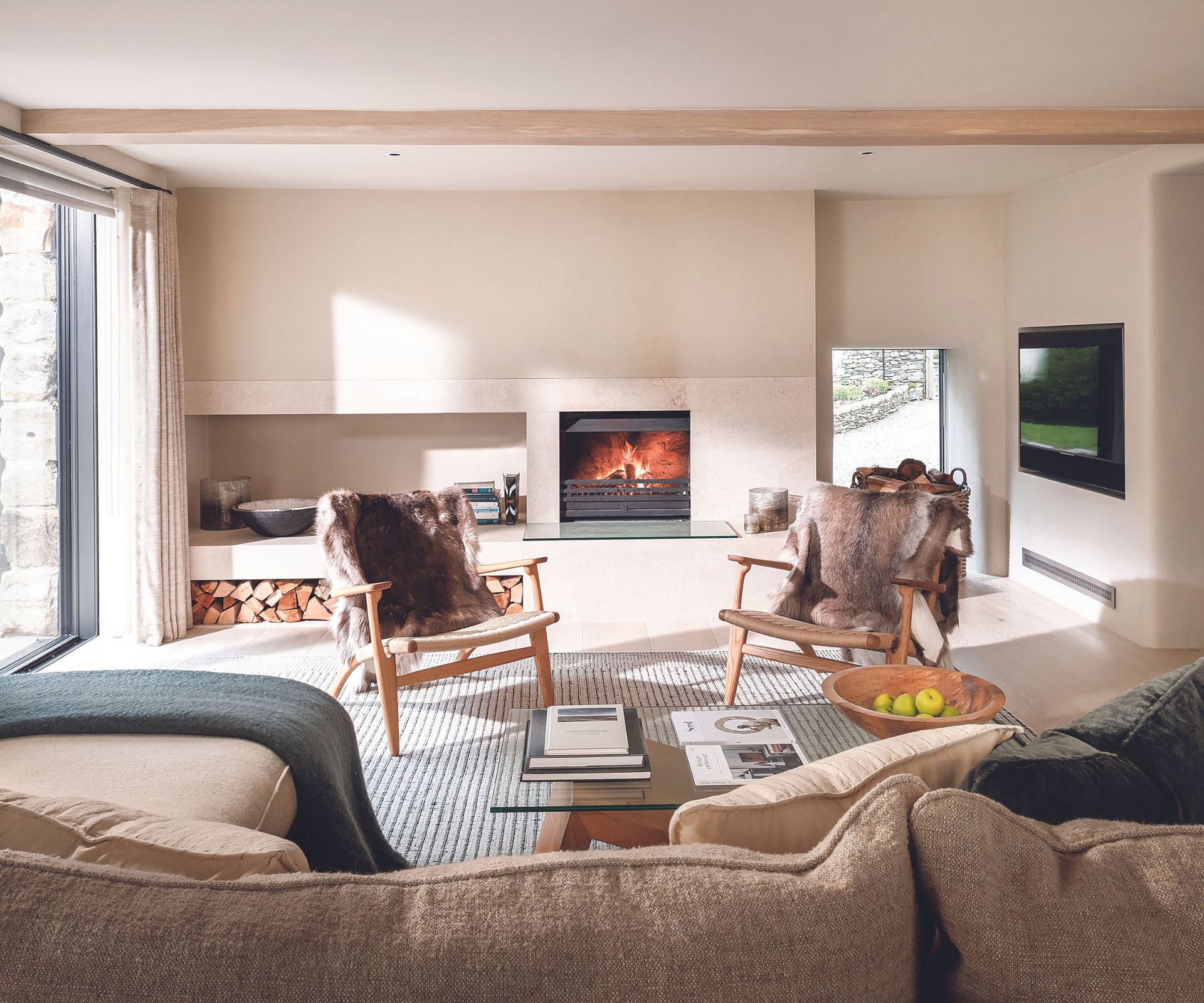 Cream sofa fireplace, fur throws, wooden chairs
