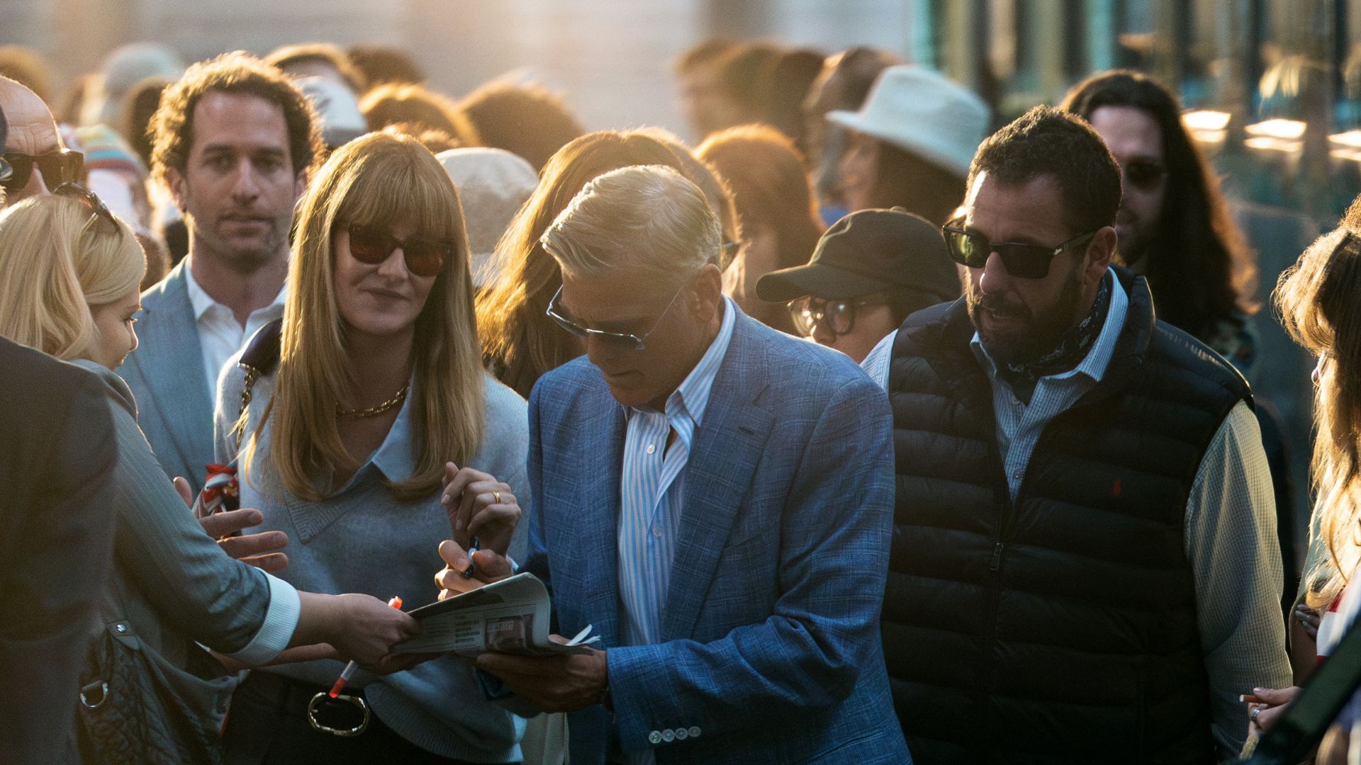 Laura Dern and Adam Sandler watch George Clooney sign an autograph