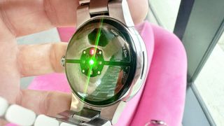 The back of the Pixel Watch 3 with a sensor light shining in green