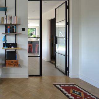 living room wood floor ideas, living room floor with rug, view through crittall doors to kitchen, shelving