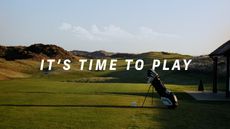 A golf bag on the 1st tee of a links course with the phrase 'It's time to play'