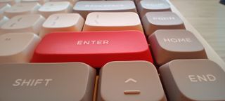 A white NuPhy Air75 V2 keyboard on a wooden desk