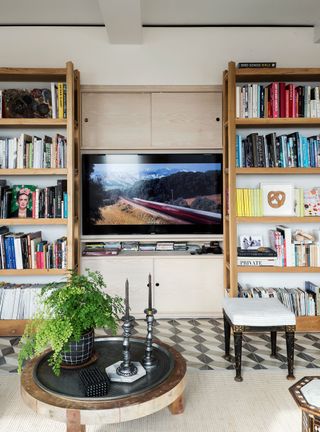 TV room with bookcase built around a central TV on a cream wall