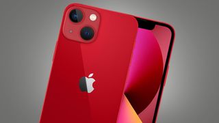 A red iPhone 13 Mini on a grey background