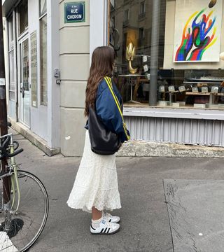 woman wearing white sneakers with spring midi skirt outfit