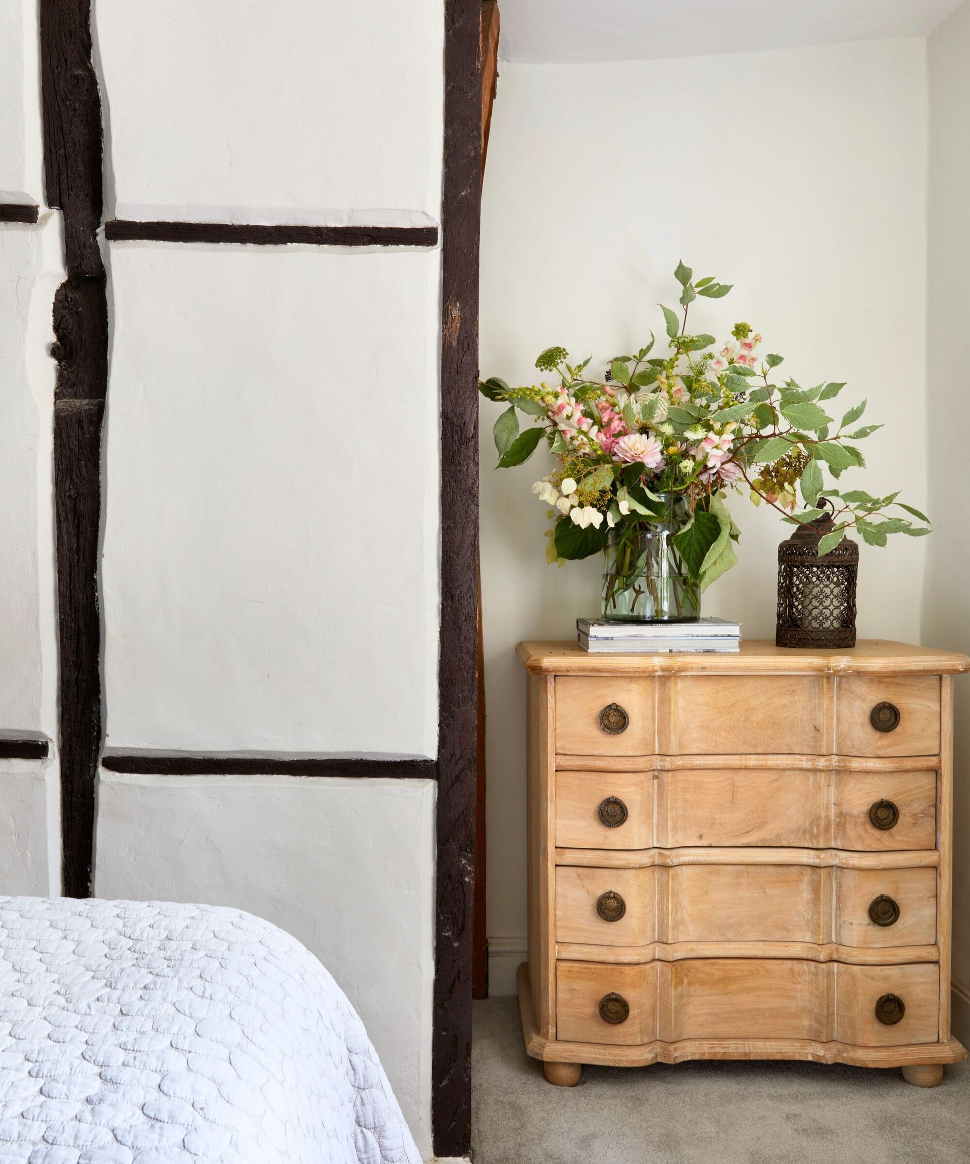 Bedroom chest of drawers styled with a large vase of flowers