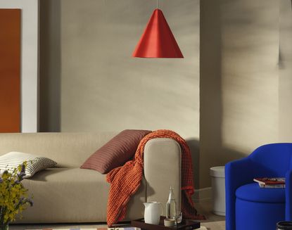 red pendant light hanging over a blue sofa