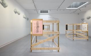 artworks on wooden frameworks in gallery space