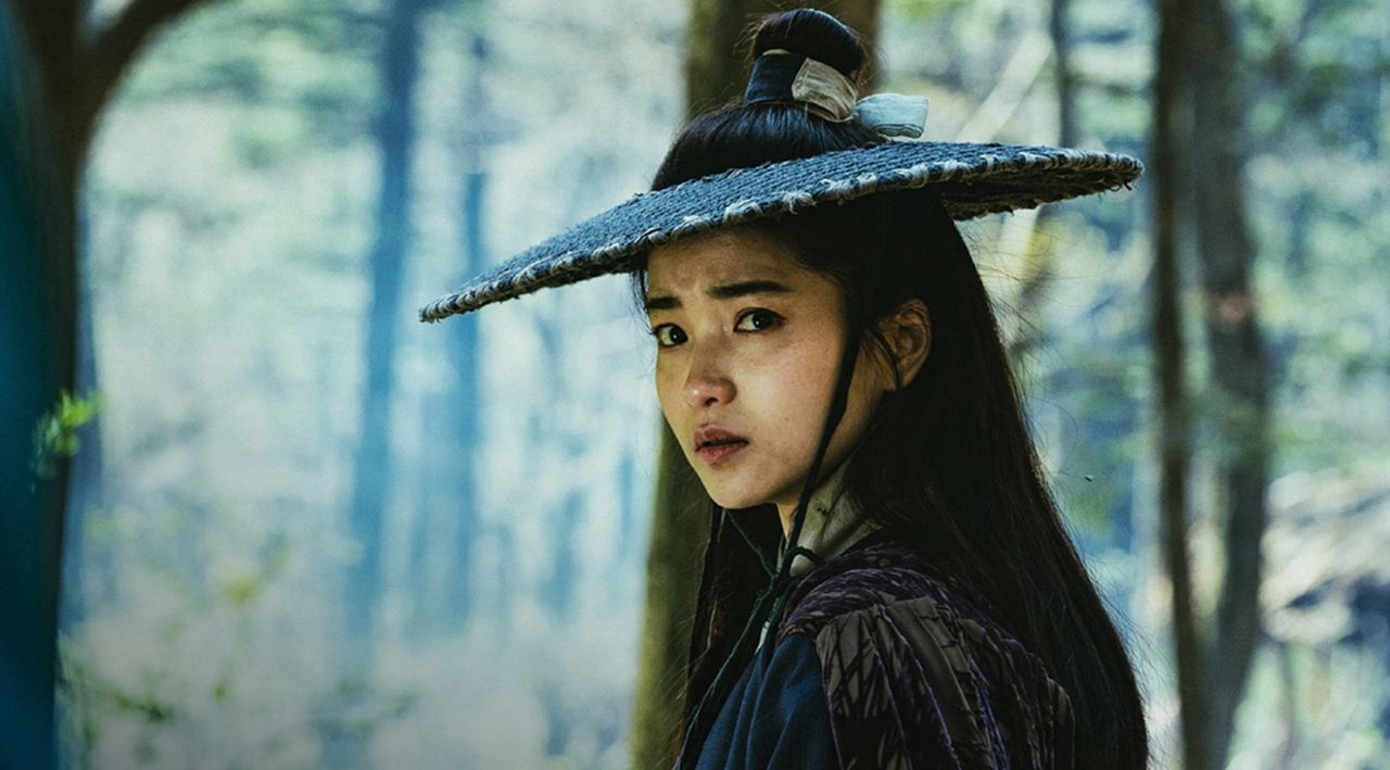 a still from alienoid 2 of a woman in a period accurate straw hat in the woods