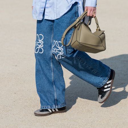 woman wearing jeans, adidas, and a loewe bag 