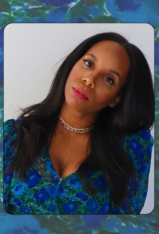 Stylist Cindy Conroy wearing a blue and green floral top with a gold chain and red lipstick.