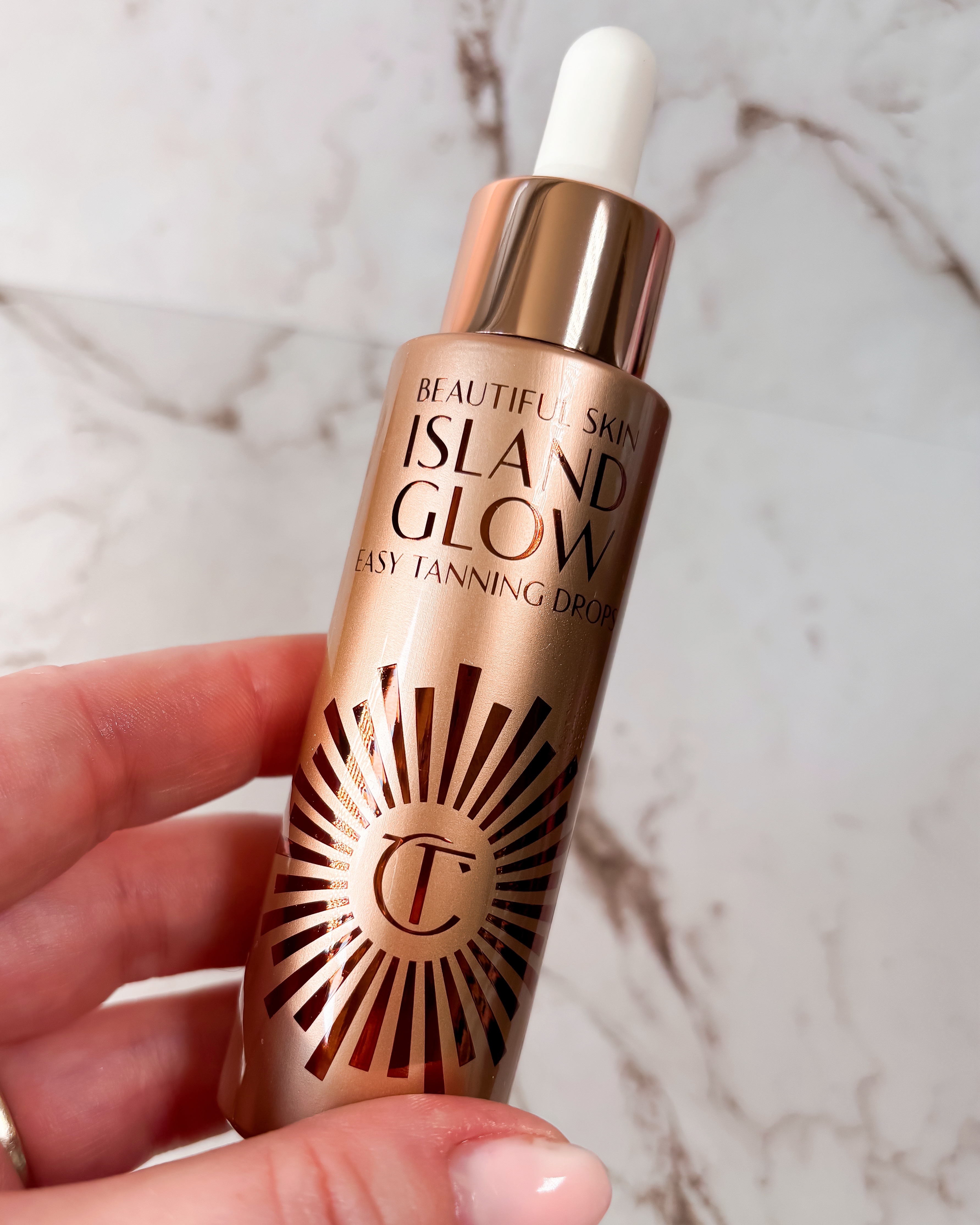 A photo of Charlotte Tilbury Tanning Drops against a marble background