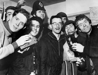 Radio Caroline DJs including Dave Lee Travis (in hat) and Tony Blackburn (second right) at Walton police station in Essex after being rescued when their ship ran aground in January ’66.