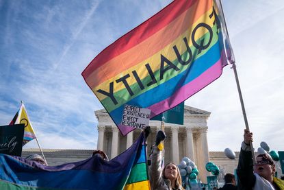 Protesters waving LGBTQ equality flags outside of the U.S. Supreme Court.
