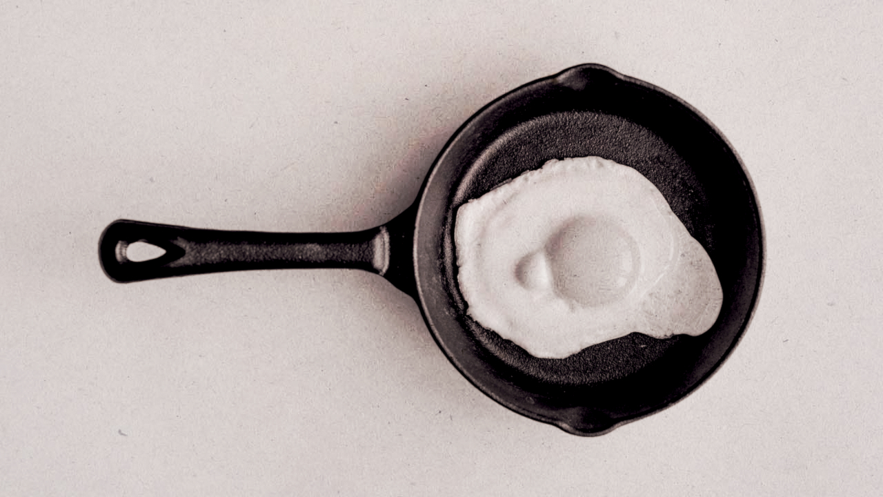 Photograph of an egg frying in a pan, edited to resemble the 1987 &#039;this is your brain on drugs&#039; PSA.
