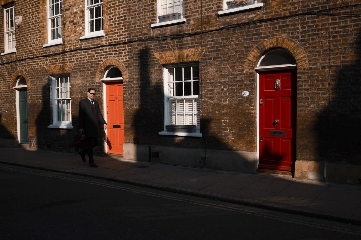 London street photo of people walking down old street in bright sunlight with strong shadows cast on the wall, taken with the Sigma BF camera and Sigma 35mm F2 DG lens