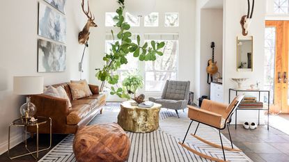 living room with white walls rocking chair tall plant and retro leather couch