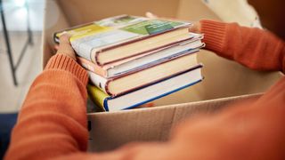 Woman packing old books into a box