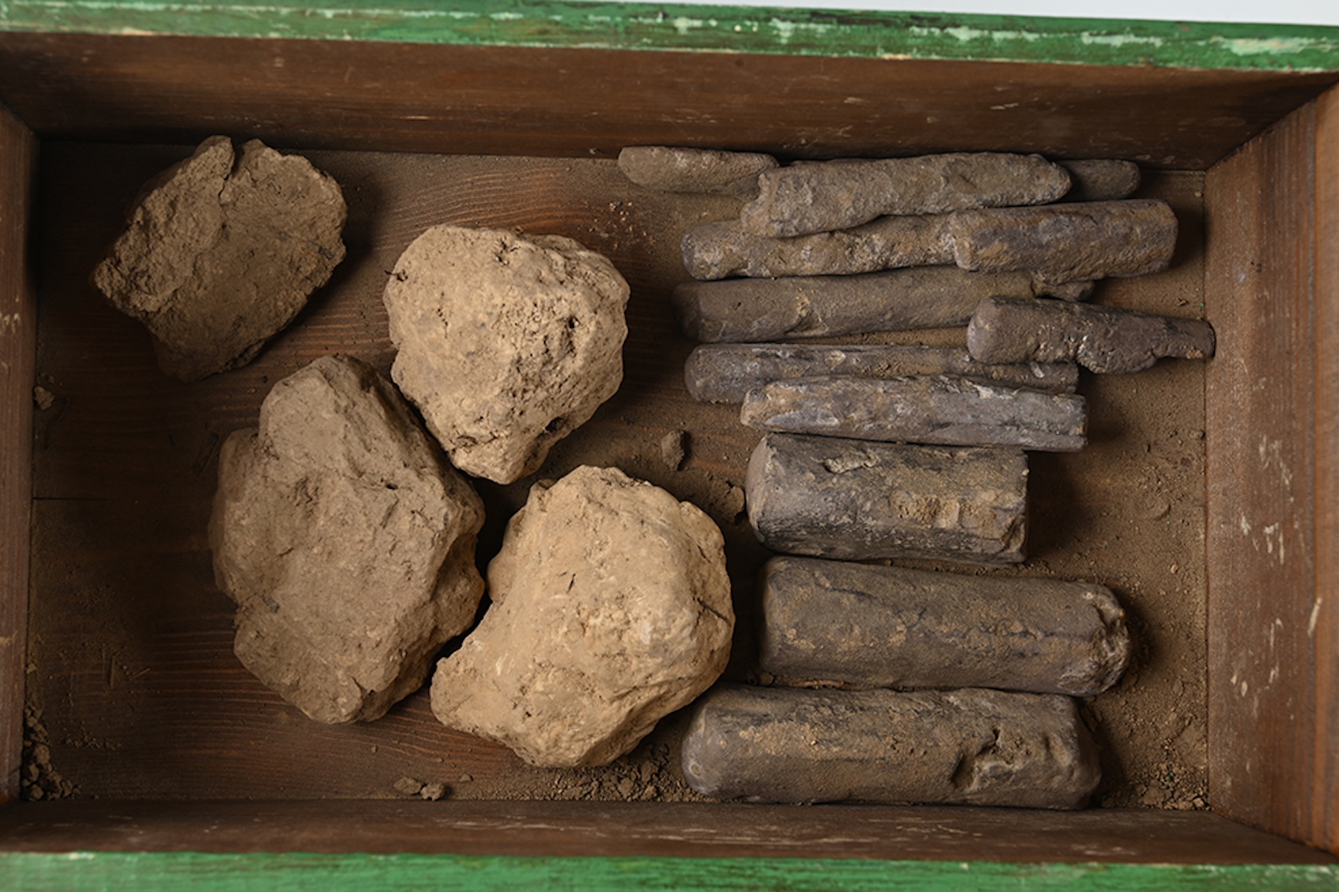 a collection of artifacts covered in dirt in a box