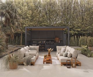 aluminium luxury dark grey pergola over outdoor kitchen area with seating in front