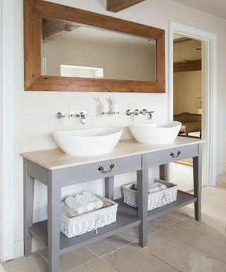 bathroom with white wall and sink with wooden framed mirror