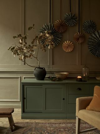 paper pin wheel decorations above a green sideboard