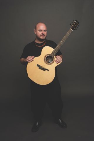 Andy McKee poses with his signature Greenfield acoustic