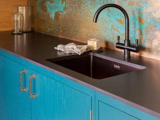 blue copper burnished backsplash, matte black countertops and blue units
