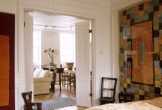 A living space with hanging rug wall art