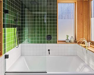 A bathtub with green and white geometric square tiles
