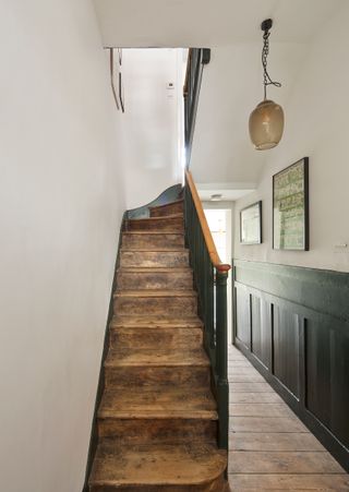 hallway in Victorian house with green wall panelling and wooden staircase