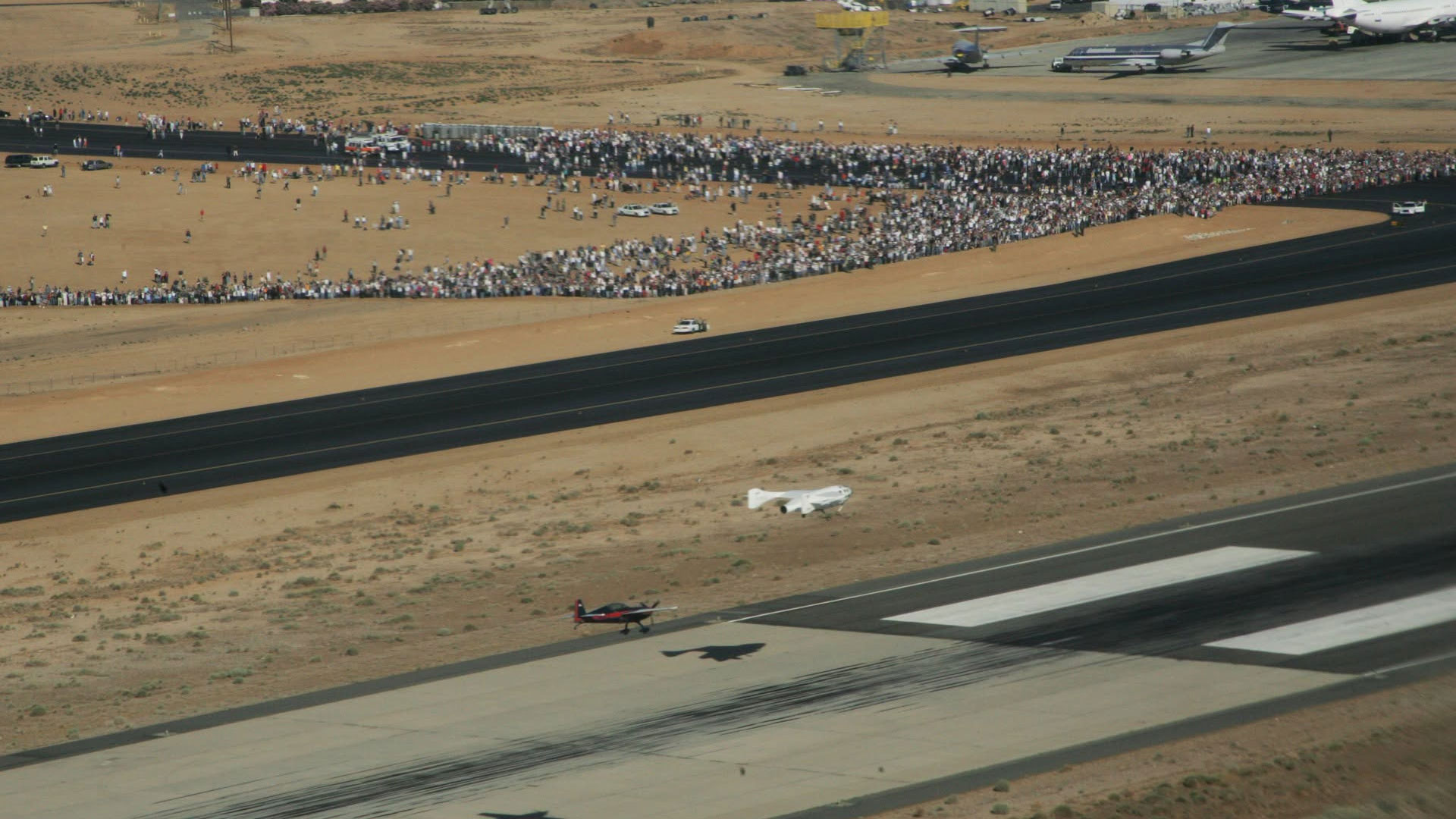 A small winged spacecraft glides to a landing on a desert strip after completing a suborbital spaceflight