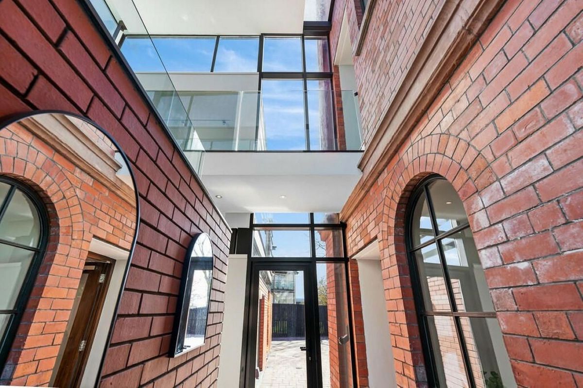 A view inside the tower showing the glass walls and windows separating the new aspects of house to divide the extension from the old red brick structure