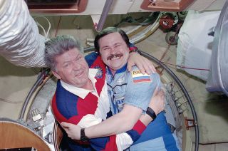 Cosmonauts Valery Ryumin (left) and Nikolai Budarin embrace after the docking of space shuttle Discovery with the Mir space station in 1998.