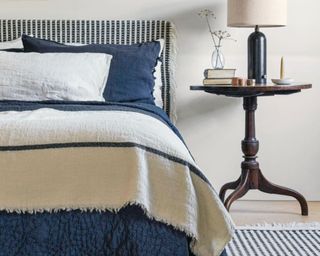 Blue bedroom with duvet cover, throw and pillows styled on bed