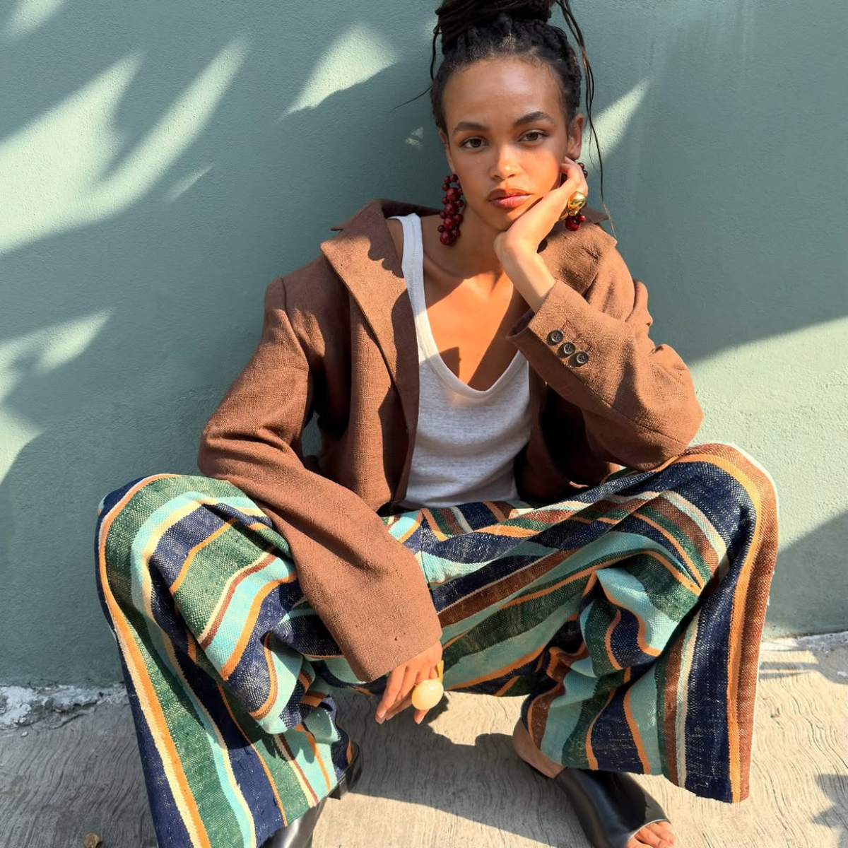 wears best designer slides and stripey trousers