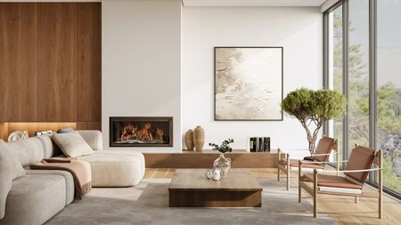 A bright minimalist living room with couch, tree, grey rug, wooden panelling, lit fireplace and large windows