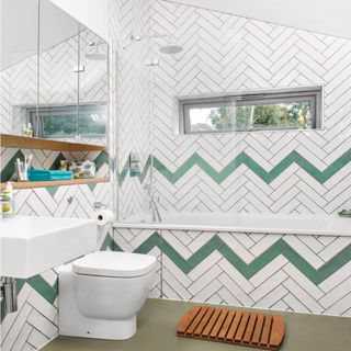 Attic bathroom with white and green chevron wall and bath tiles