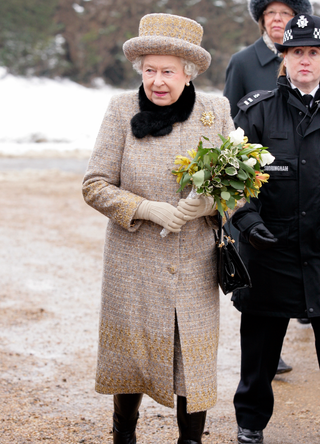 Queen Elizabeth II carries a bouquet of flowers as she leaves the church of St Peter and St Paul in West Newton after attending Sunday Service on February 5, 2012 in King's Lynn, England