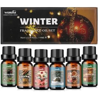 A set of six essential oil bottles in front of a box with a bauble on it that reads 'Winter fragrance oil set'