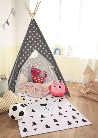 kids room with wooden flooring and star printed black tent