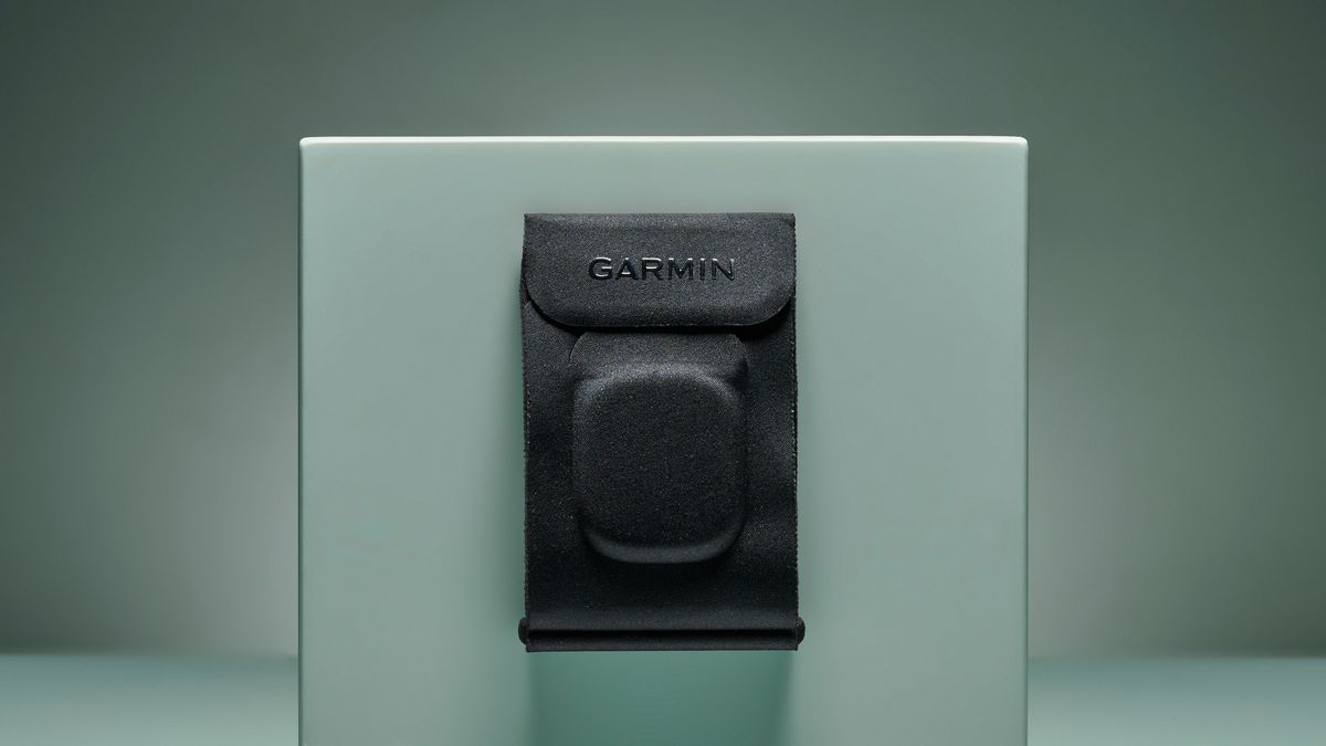 Black fabric Garmin Index Sleep Monitor armband pinned on turquoise box