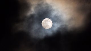 The Moon rising surrounded by cloud