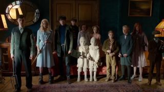 The young cast of Miss Peregrine's Home for Peculiar Children standing together in a study.