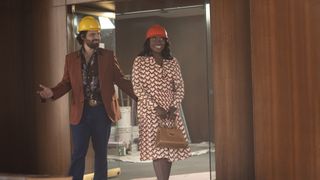 Jake Johnson and Idara Victor walking through a building with hard hats in Minx